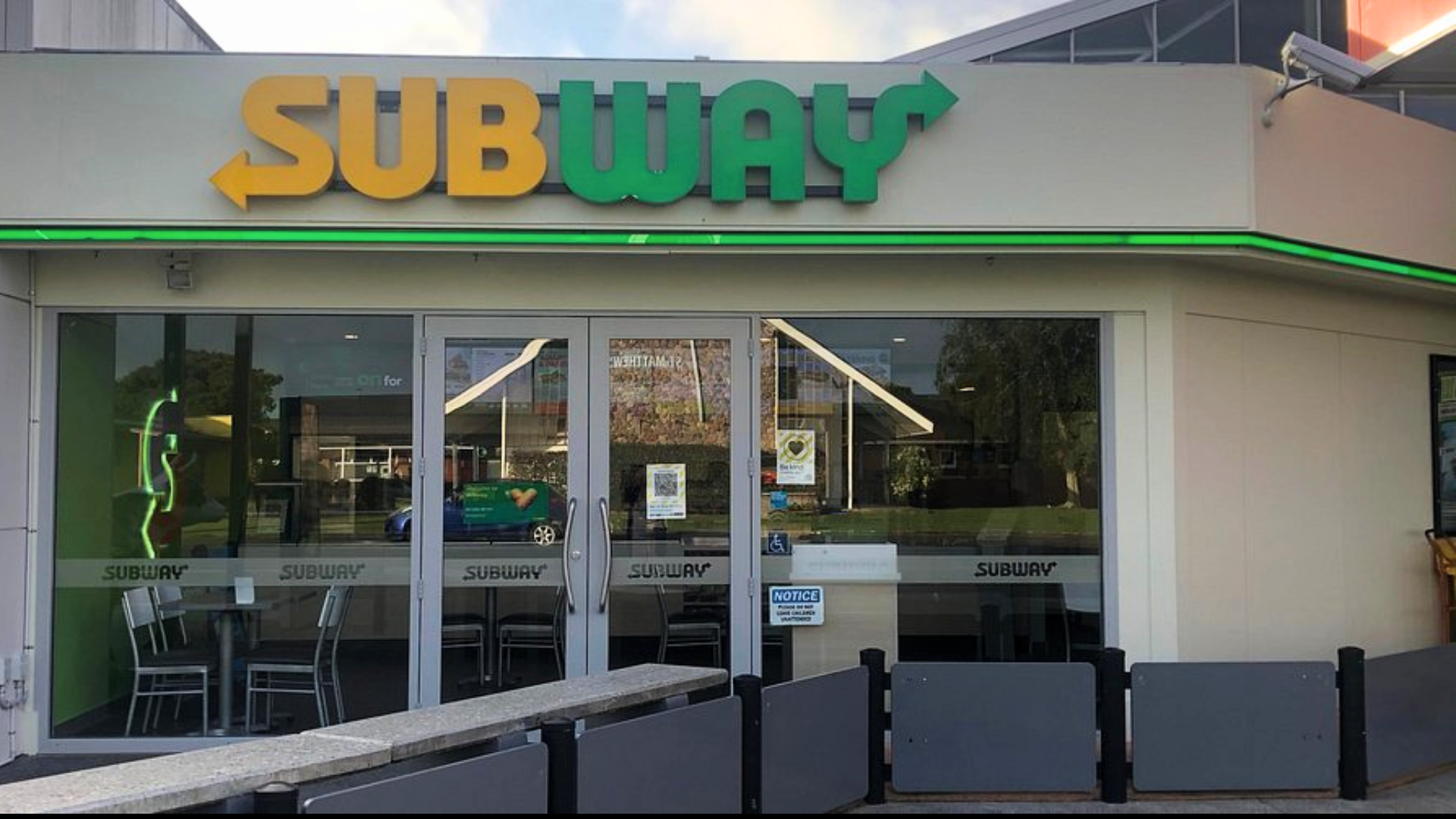 Exterior view of a Subway restaurant storefront with the company logo above glass doors.