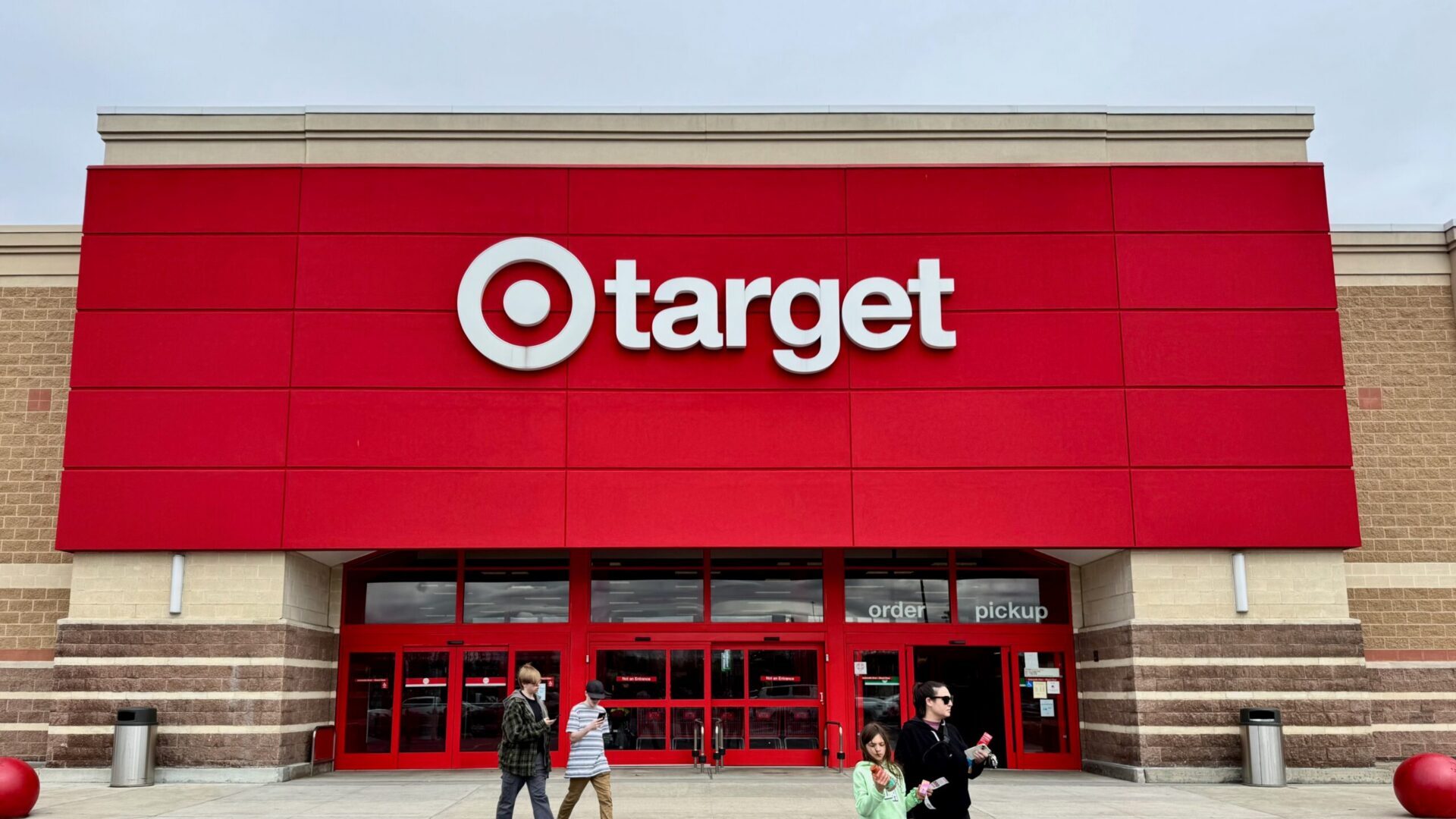 Customers waiting in line outside a store entrance.