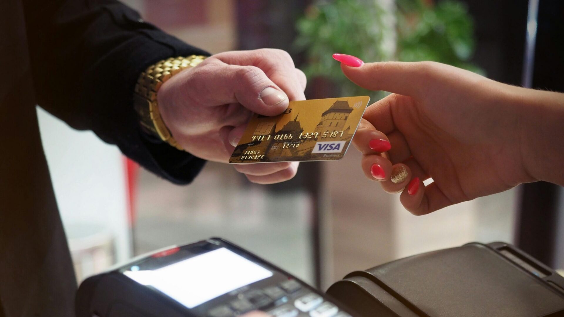Black contactless payment terminal placed on a checkout counter.