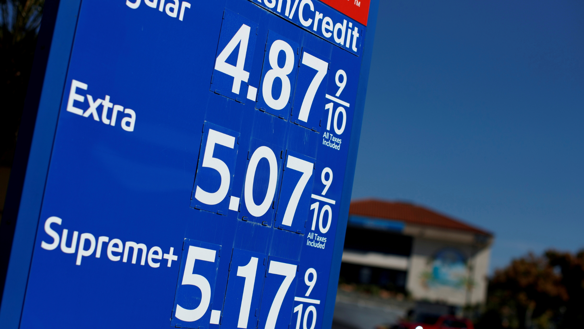 A gas station sign displaying prices for Regular, Extra, and Supreme fuel over four dollars per gallon.