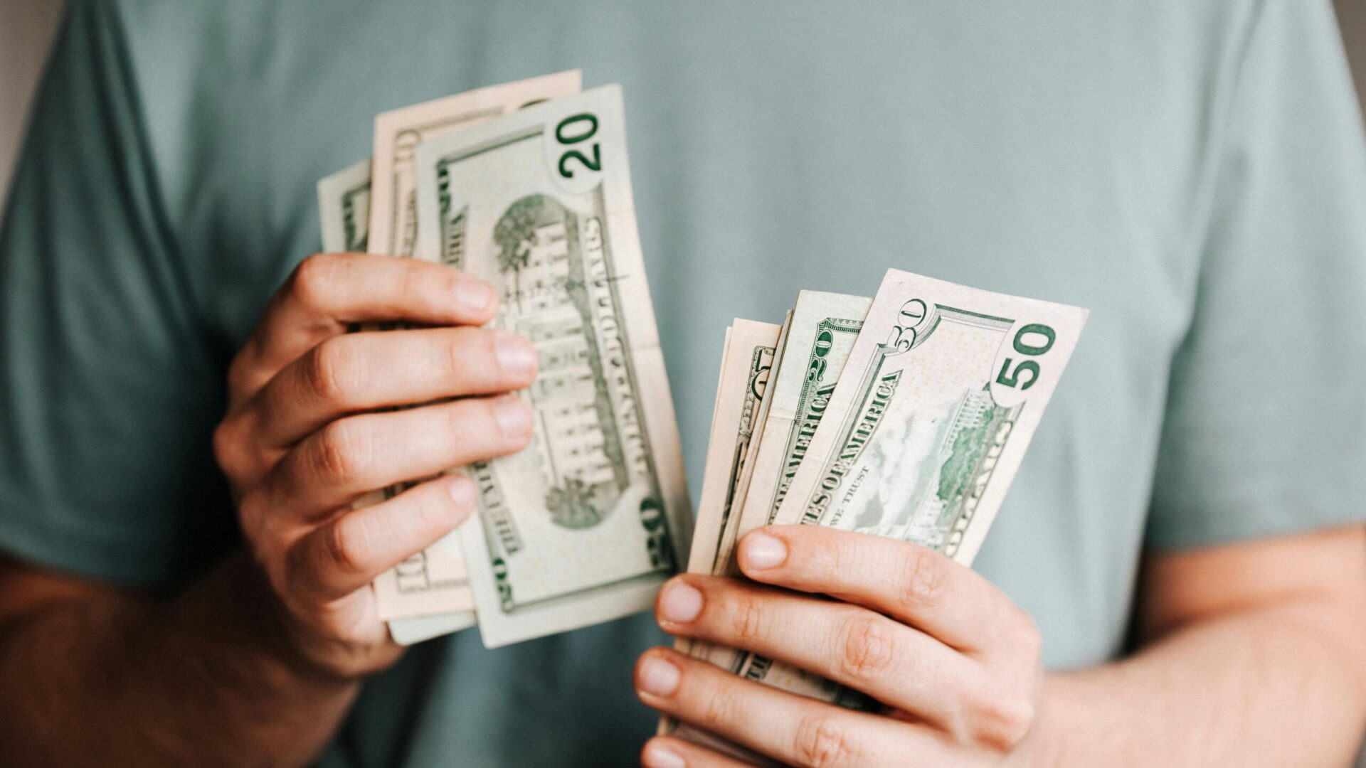 Man counting U.S. dollar banknotes in his hands.