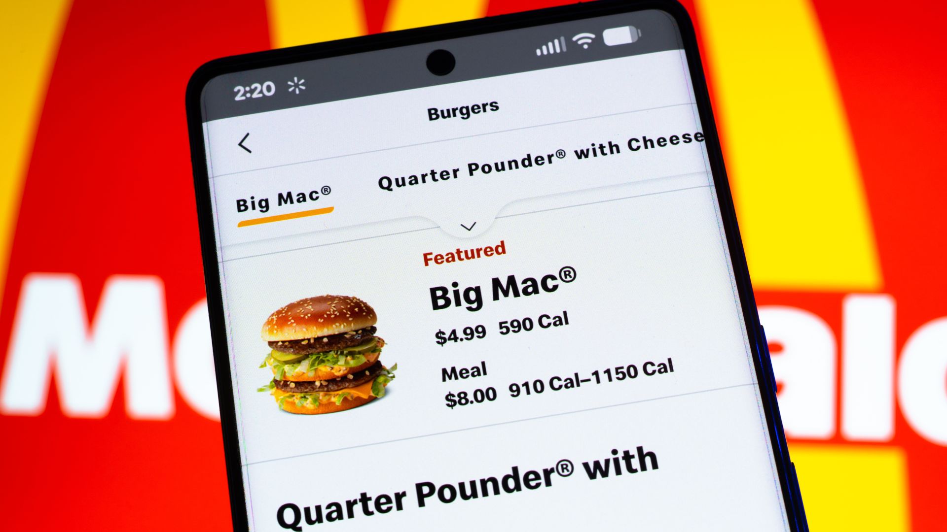 Smartphone displaying McDonald’s menu with Big Mac pricing on screen.