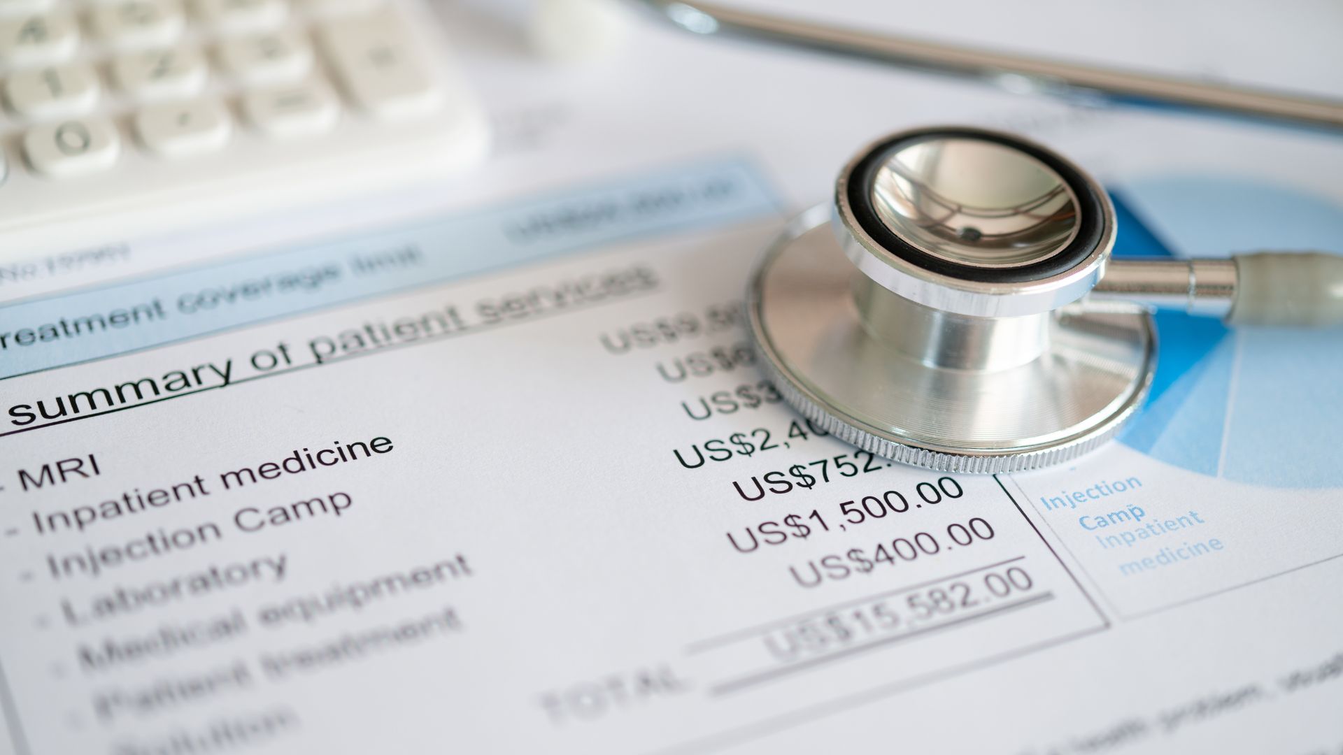 Medical bill statement with a stethoscope and calculator on a desk.