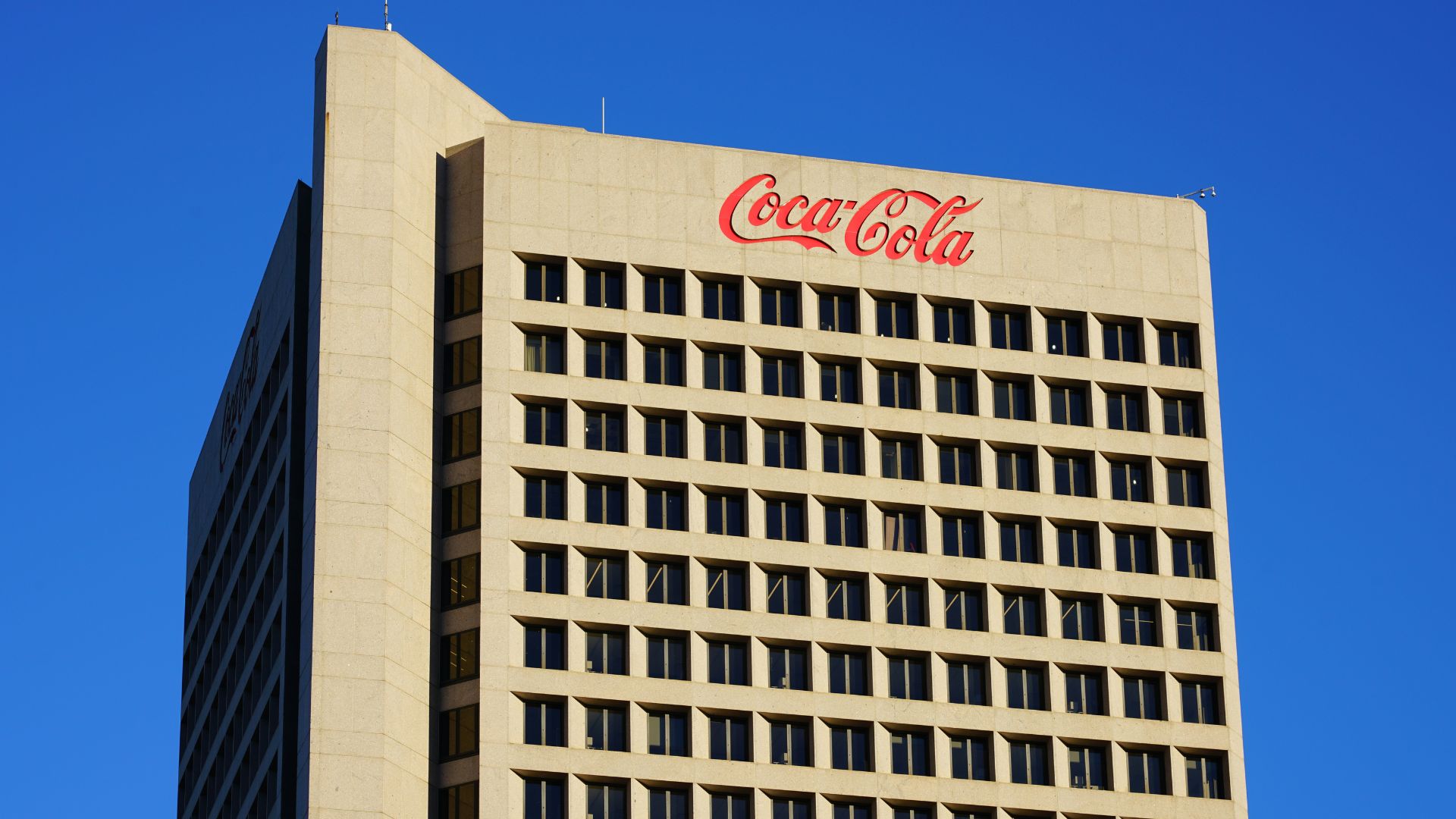 Coca-Cola logo displayed on the side of a corporate office building.