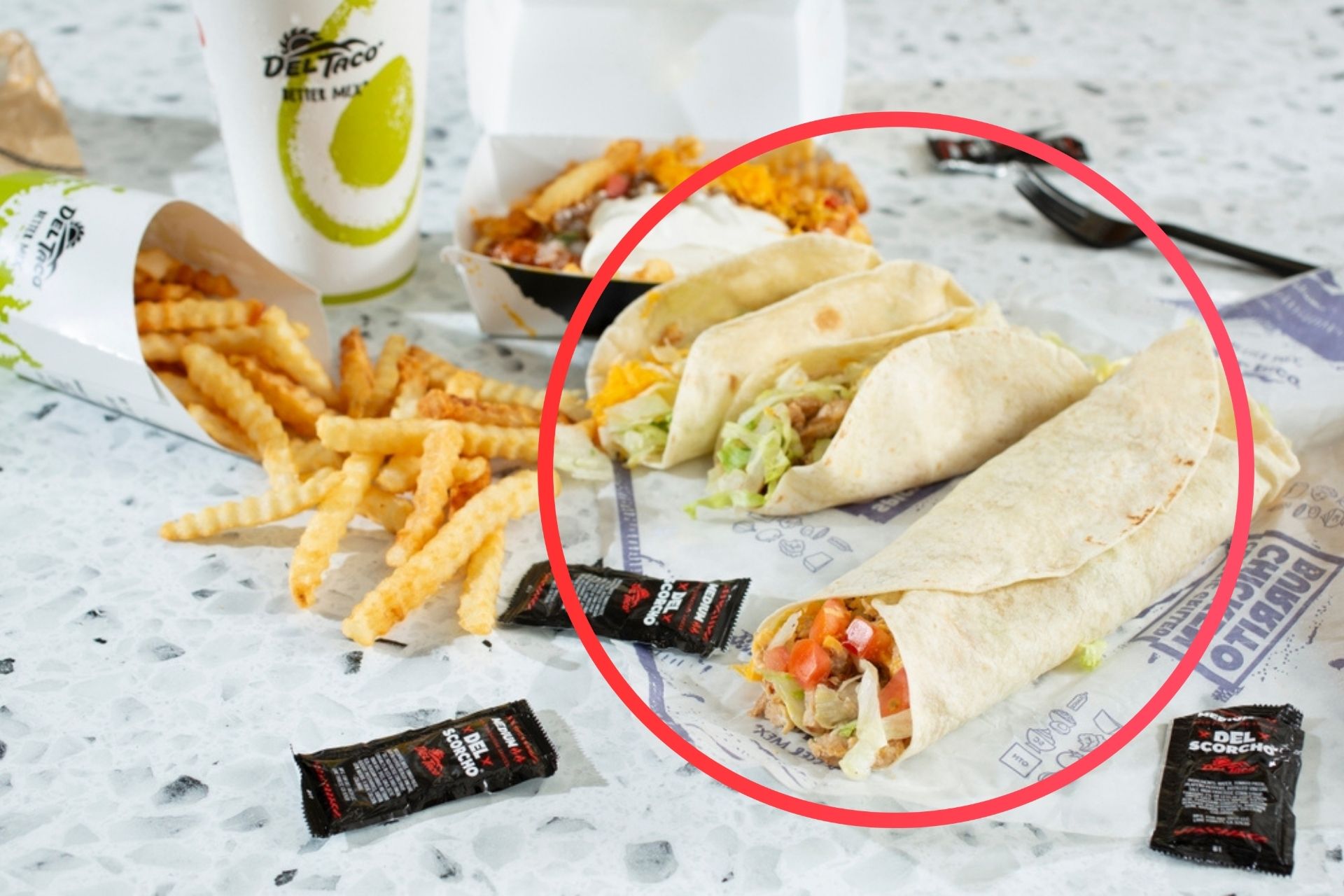 Del Taco combo meal with tacos, burrito, crinkle-cut fries, and drink, with red circle highlighting the open-ended burrito fold.