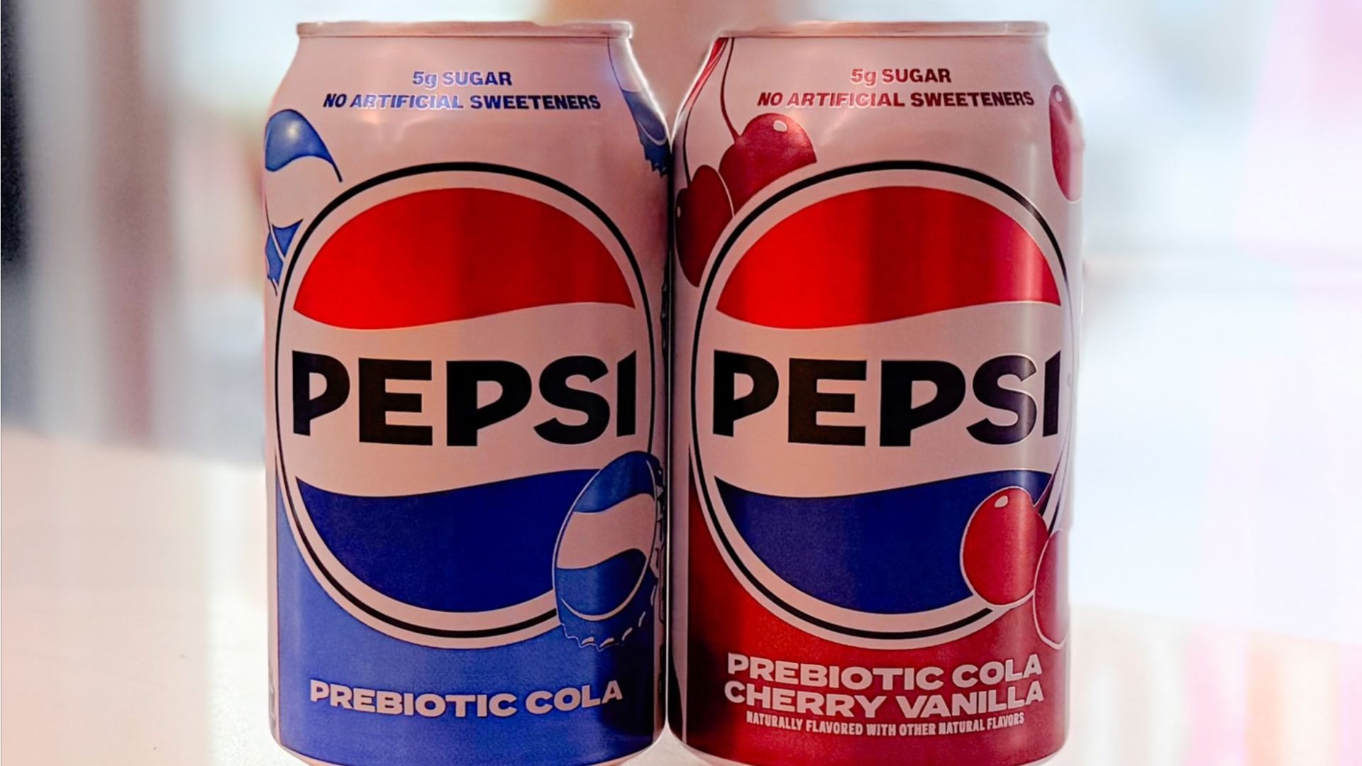 Pepsi prebiotic cola cans including classic and cherry vanilla flavors with 5g sugar label.