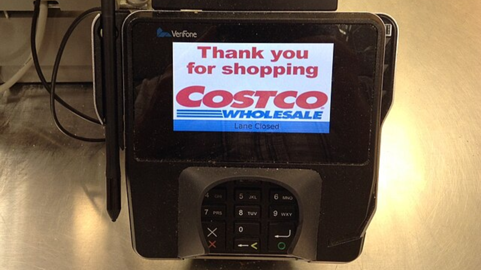 A close-up of a point-of-sale terminal at a Costco checkout displaying a "Thank you for shopping" message.