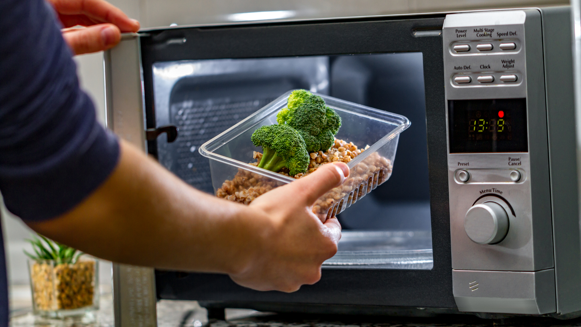 Hand Putting Food on Plastic Container to the Microwave