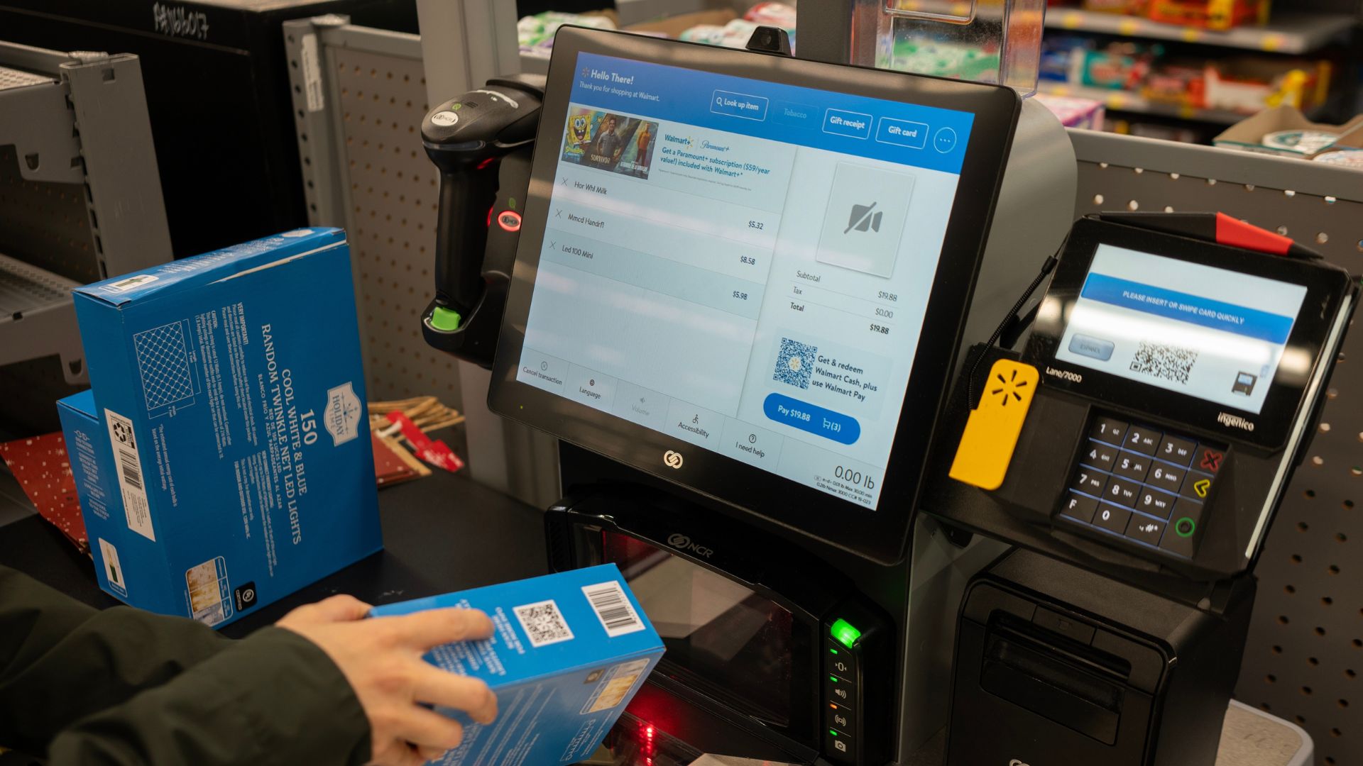 A customer scanning an item at a self-service checkout in a Walmart.