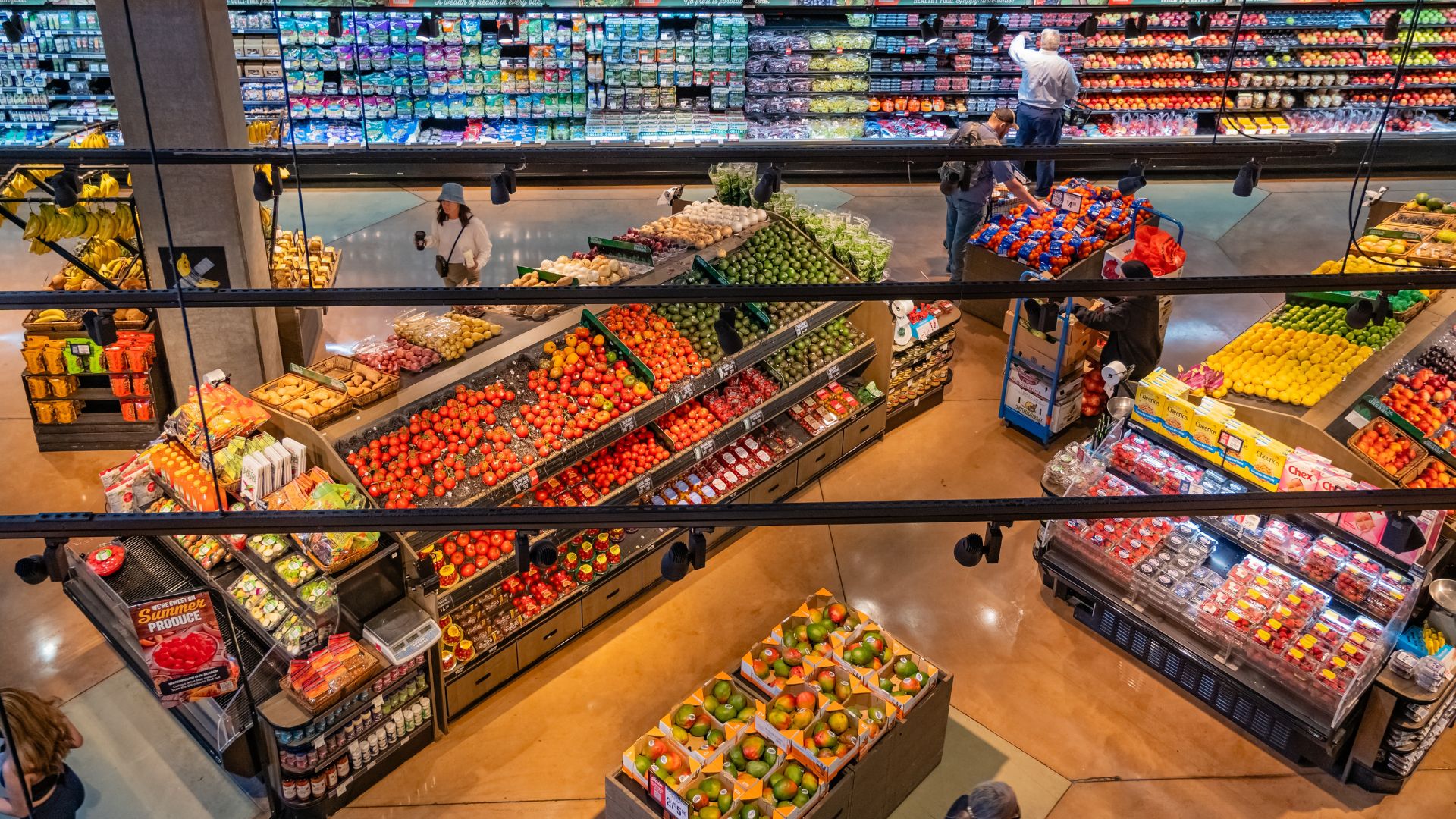 Grocery store shoppers in the vegetable and fresh produce section of a grocery store or supermarket.