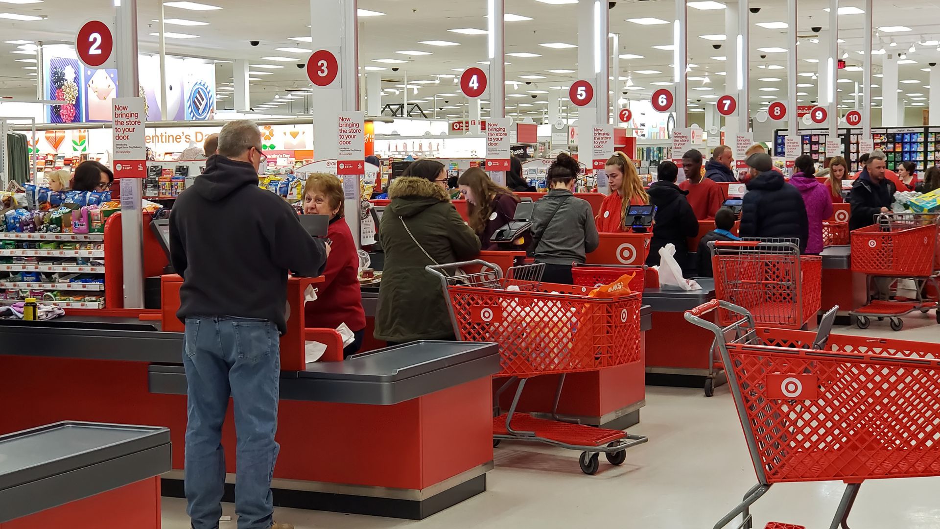Rows of traditional checkout lanes in a Target filled with customers.