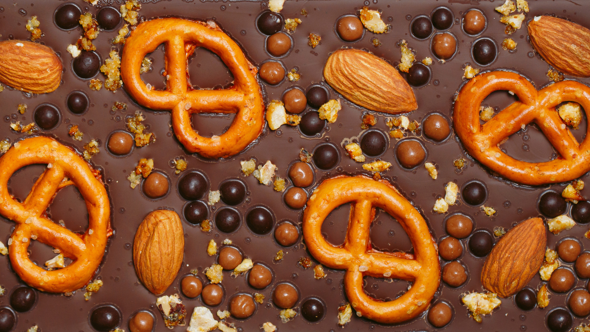 Chocolate bars with a variety of dried fruit, pretzels and nut toppings.