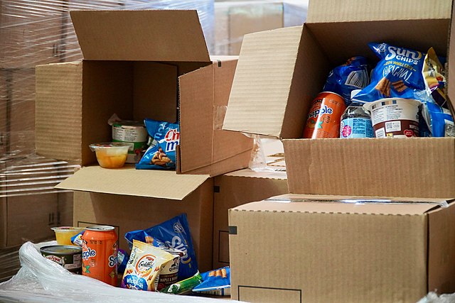 Open cardboard boxes filled with snacks and drinks.