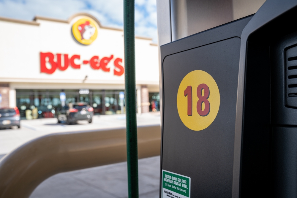 Gas pump labeled “18” in foreground with Buc-ee’s convenience store and logo visible in the background.