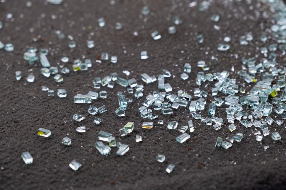 Small shards of broken glass scattered across a dark surface.