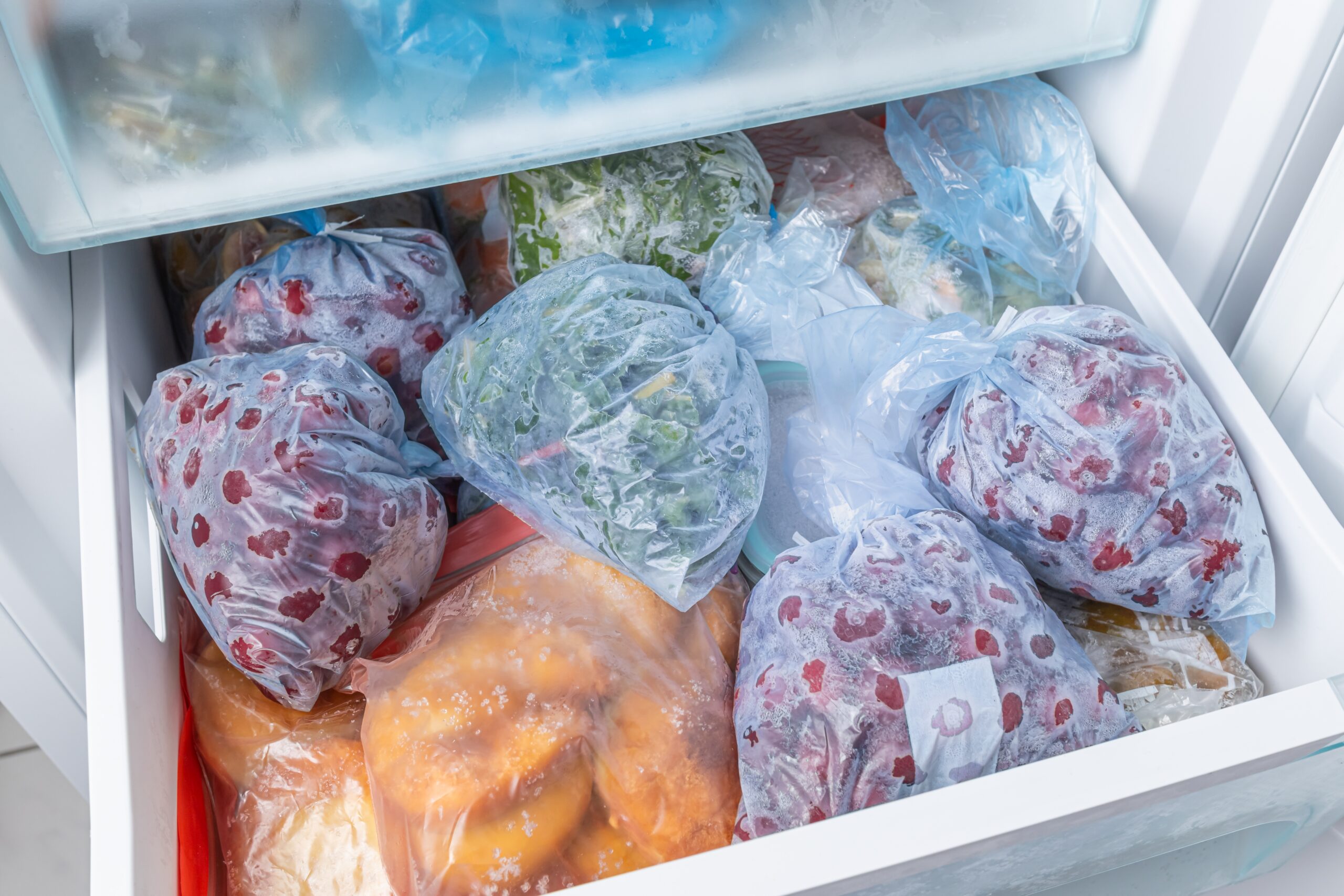 Frozen food in bags and in the lower part of the refrigerator.