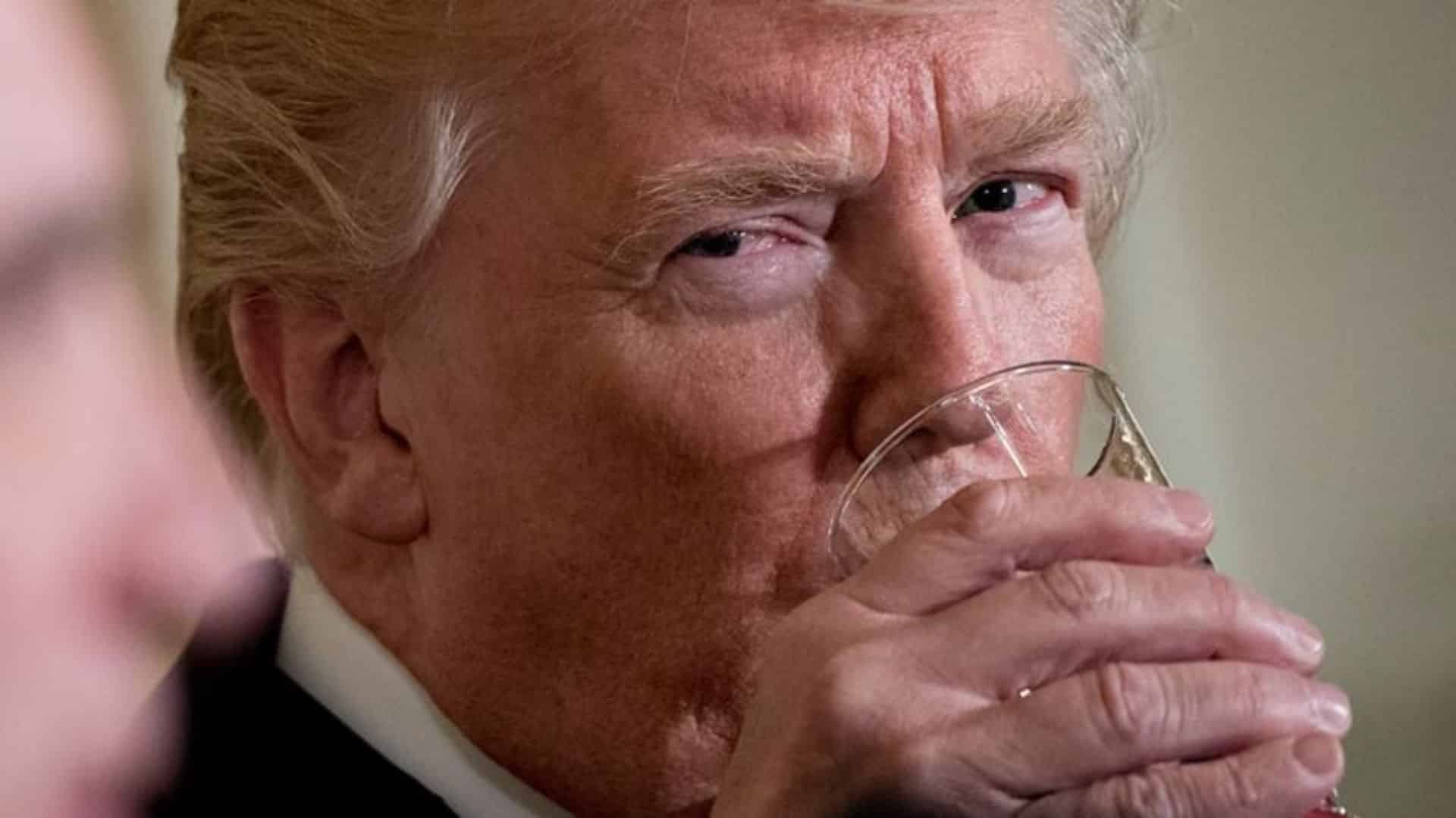 Close-up of President Trump drinking from a glass.