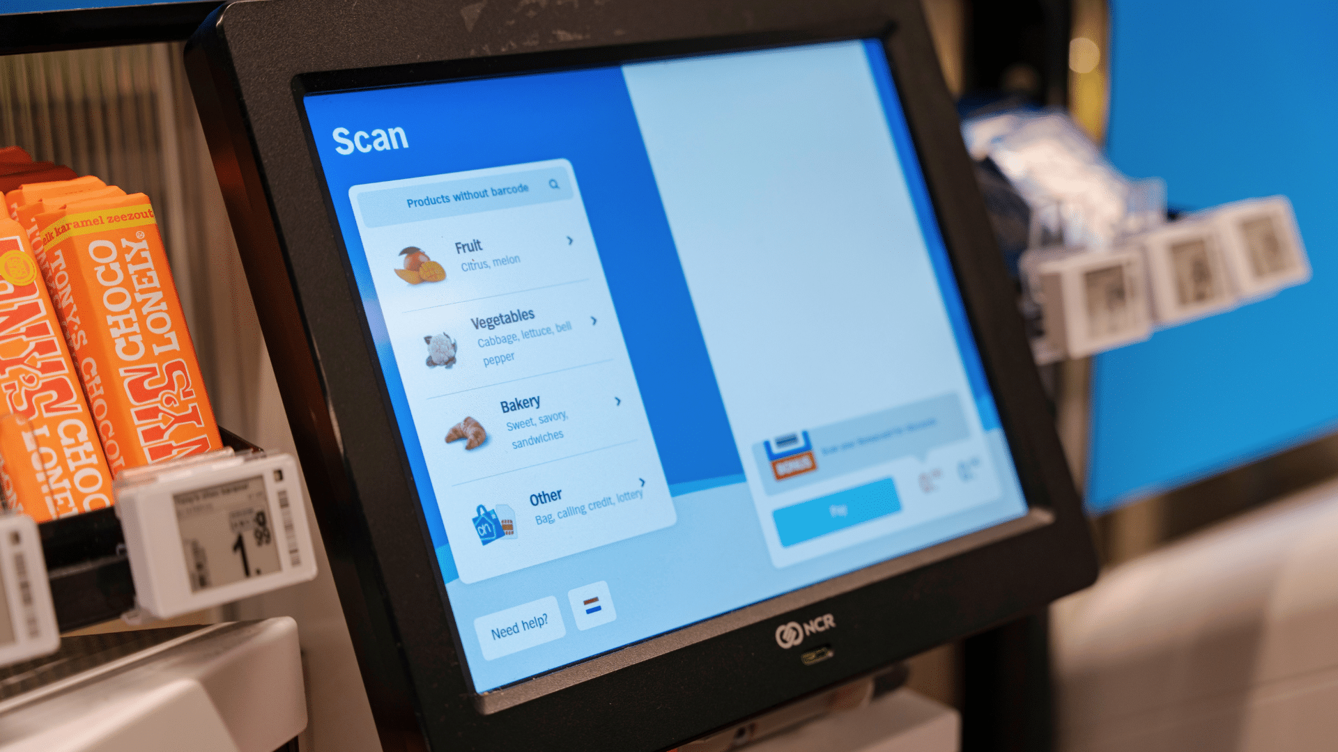 A close-up of a supermarket self-checkout screen showing a menu to select items without barcodes, like fruits and vegetables.