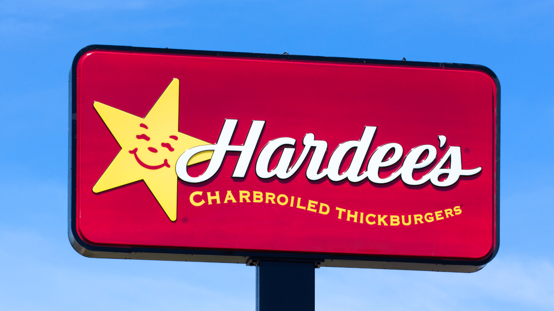 A red Hardee's sign with a smiling yellow star and the words "Charbroiled Thickburgers."