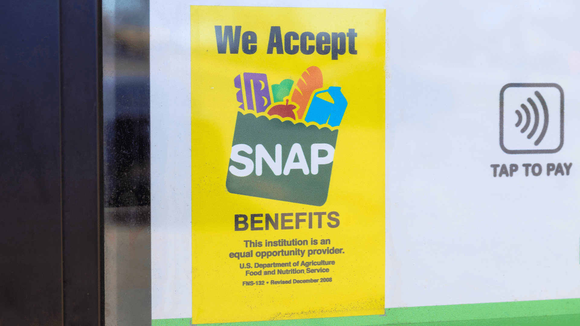 A bright yellow sign on a glass door reading