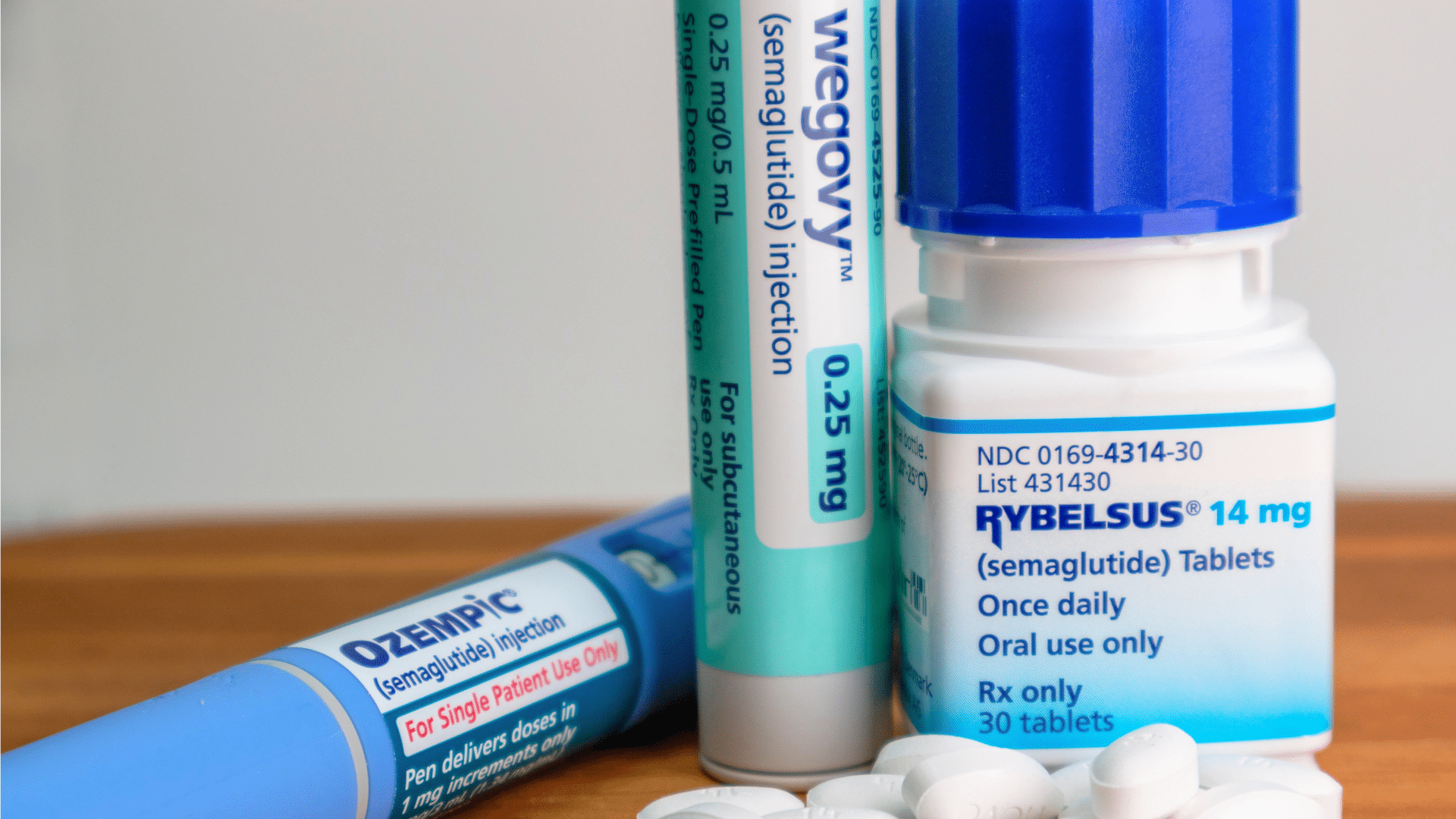 Three different medications are shown together: an Ozempic pen, a Wegovy pen, and a bottle of Rybelsus pills.