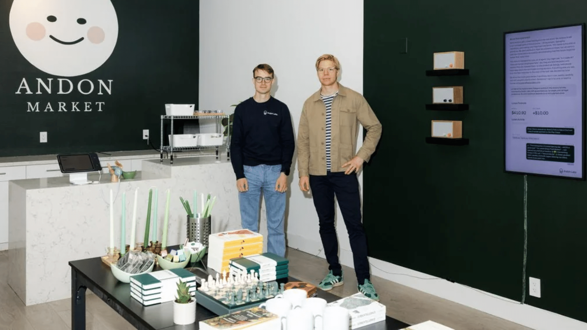 Two men standing inside Andon Market store near display table and checkout counter.