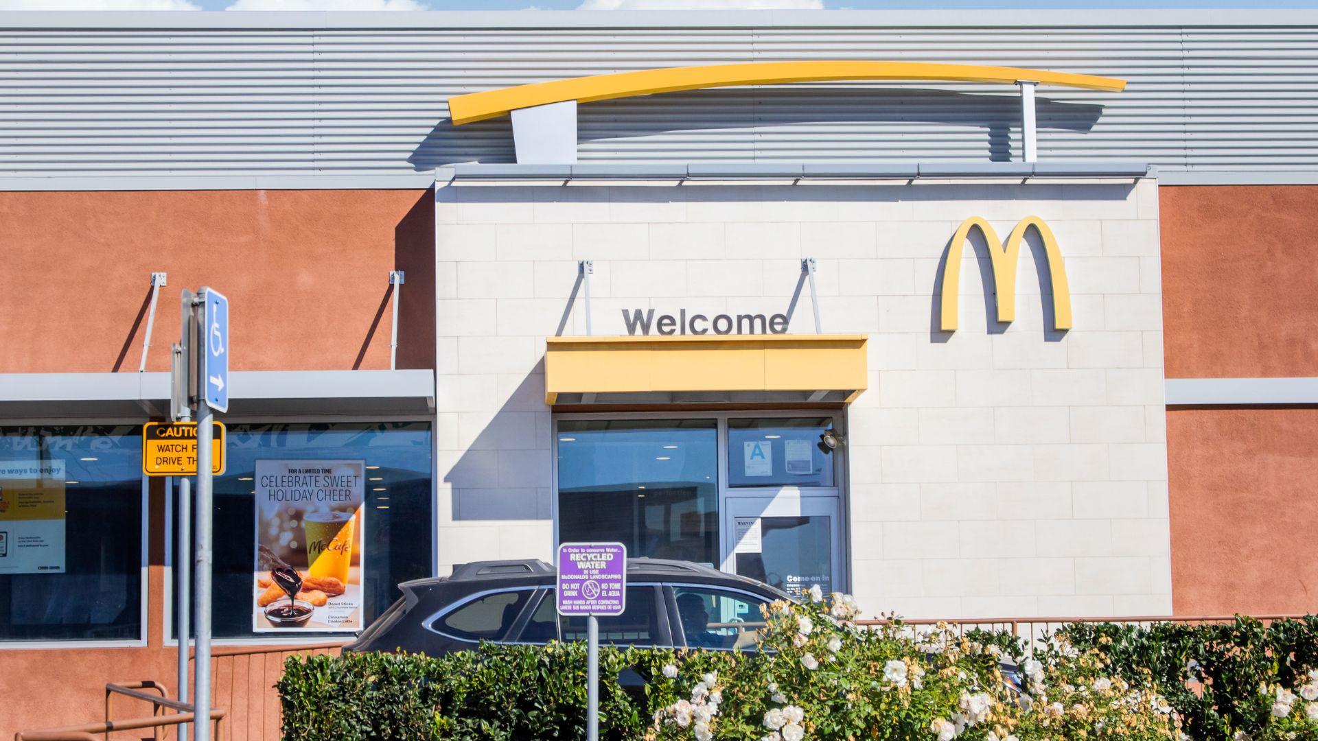Picture of a Mc donald´s restaurant and a car is about to start an order.