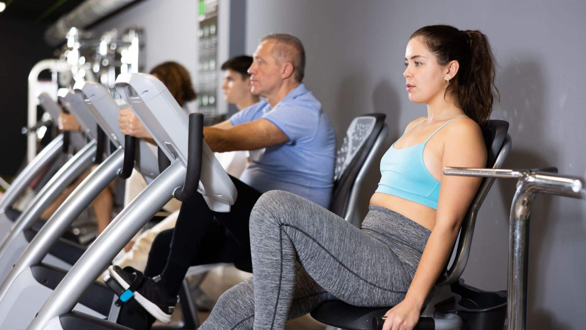 People working out at the gym, and using electric bicycles.