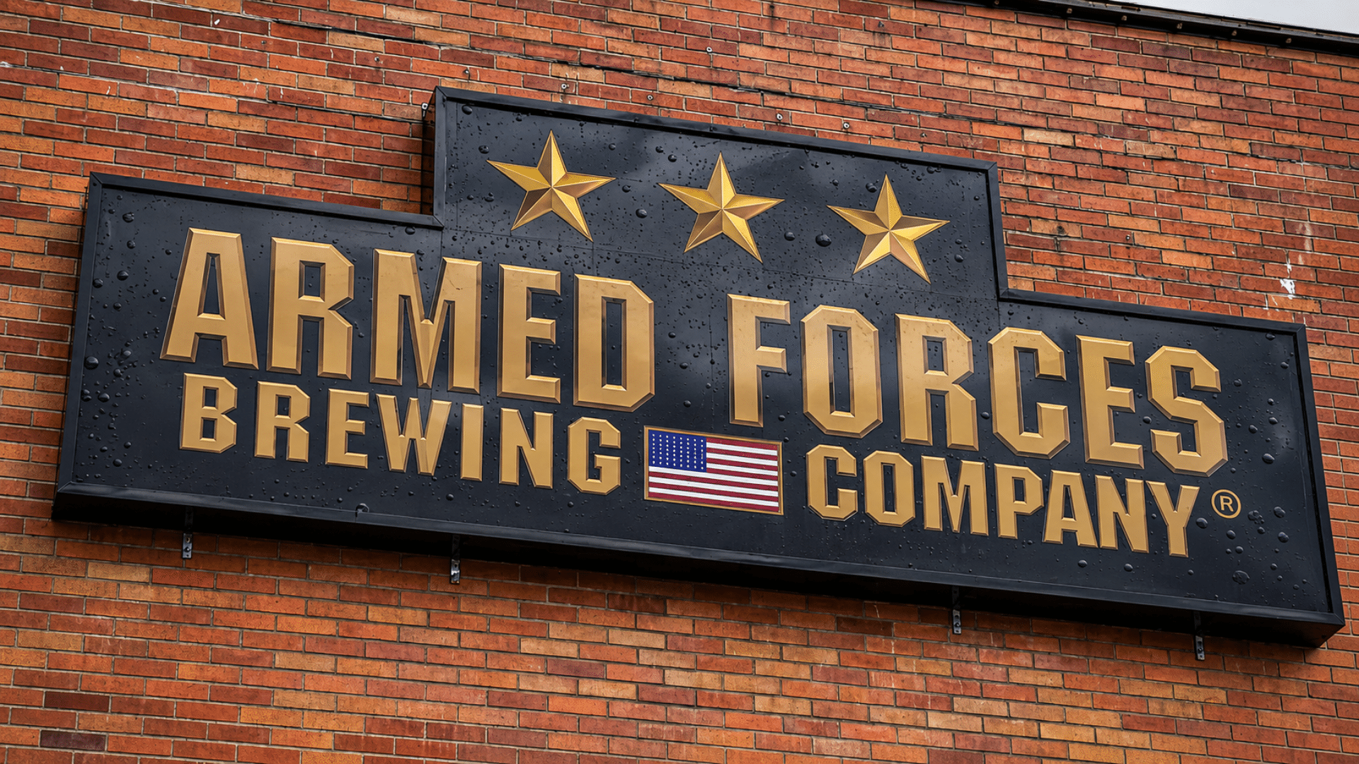 A close-up shot of a black exterior building sign featuring the words