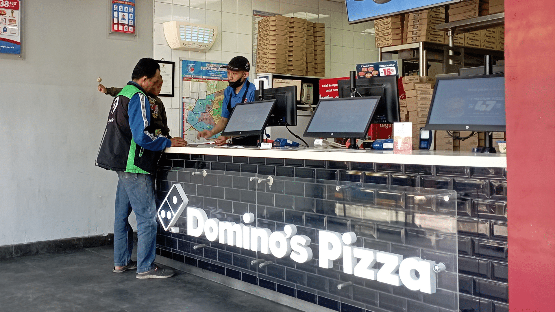 A customer placing an order at a Domino's Pizza counter.