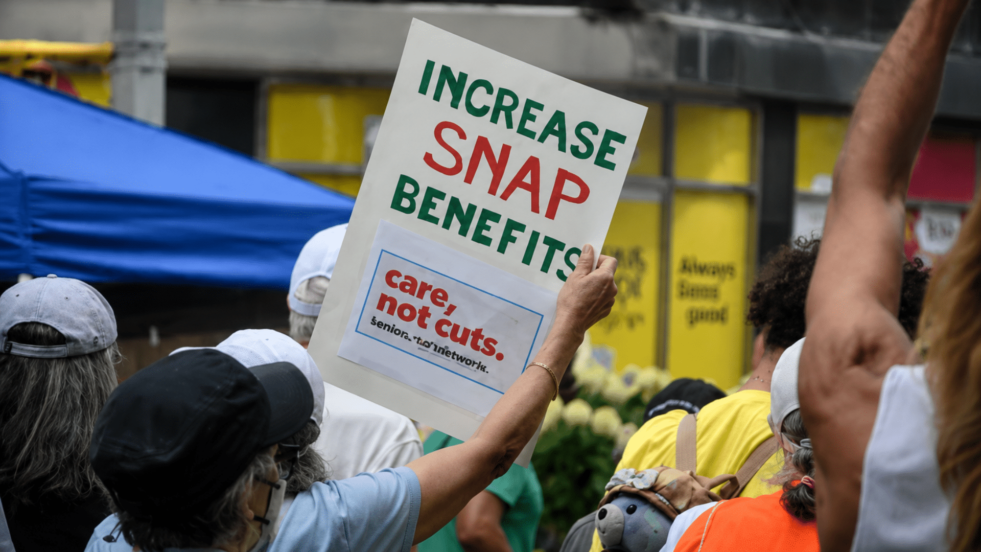 Protester holding sign calling for increased SNAP benefits at rally.
