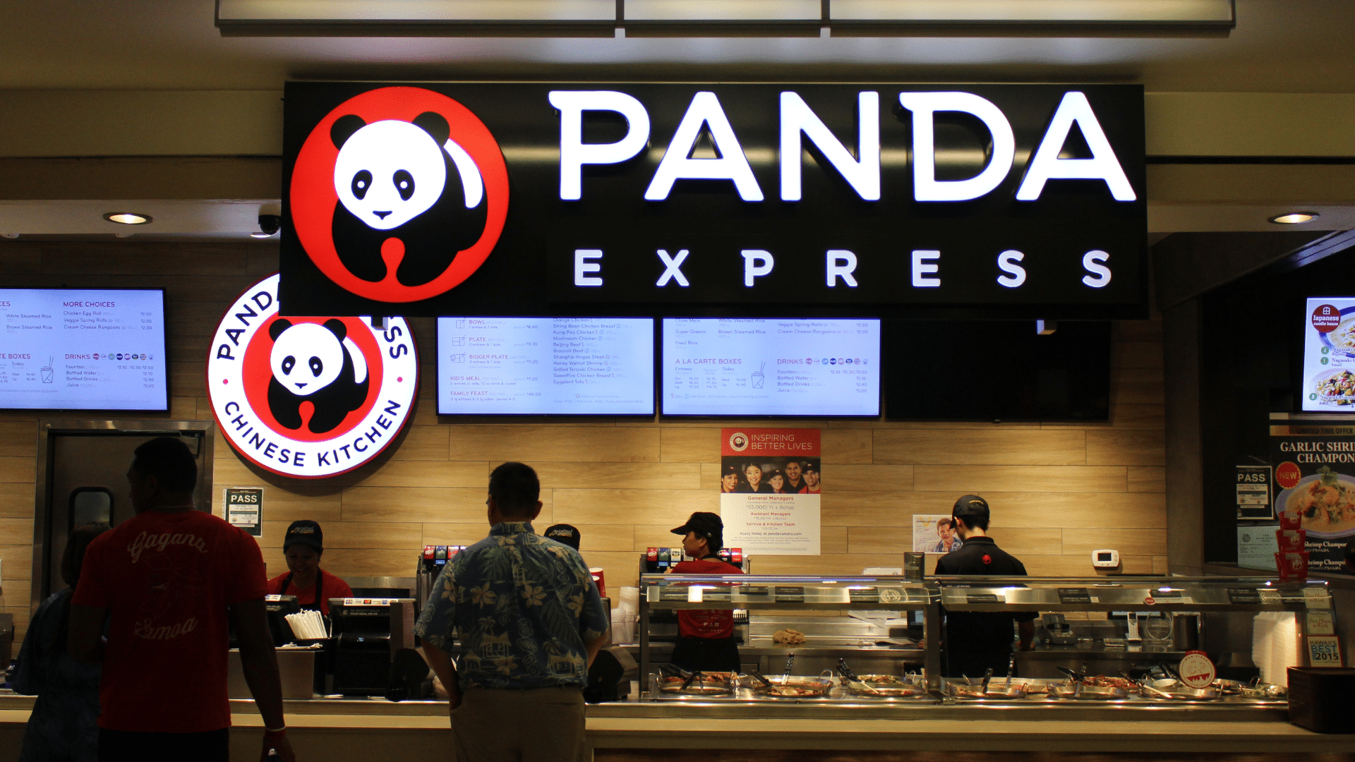 Panda Express restaurant counter with illuminated logo and customers ordering food.