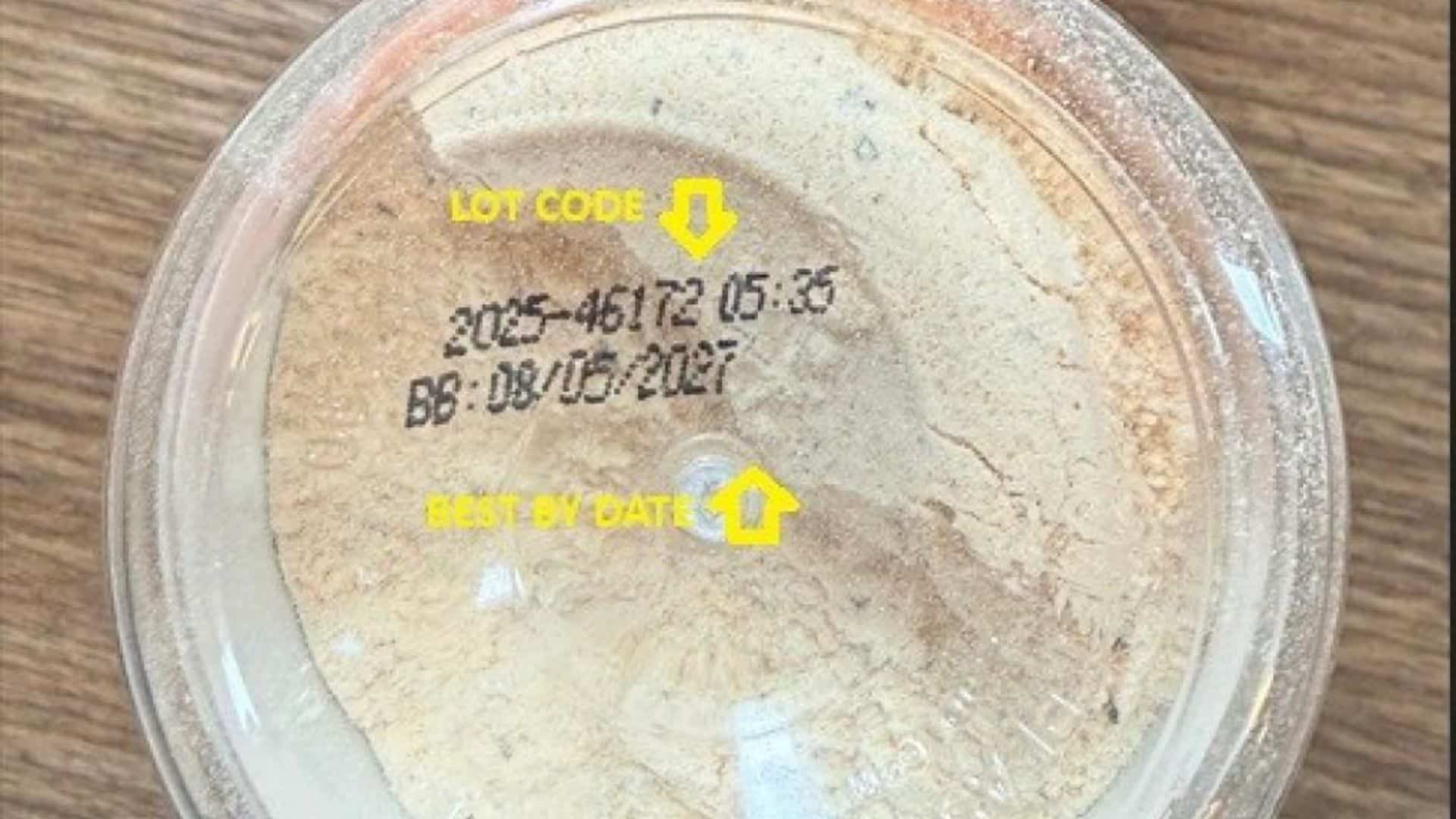 Close-up of a food container lid showing lot code and best-by date information of the recalled Parmesan Ranch seasoning.