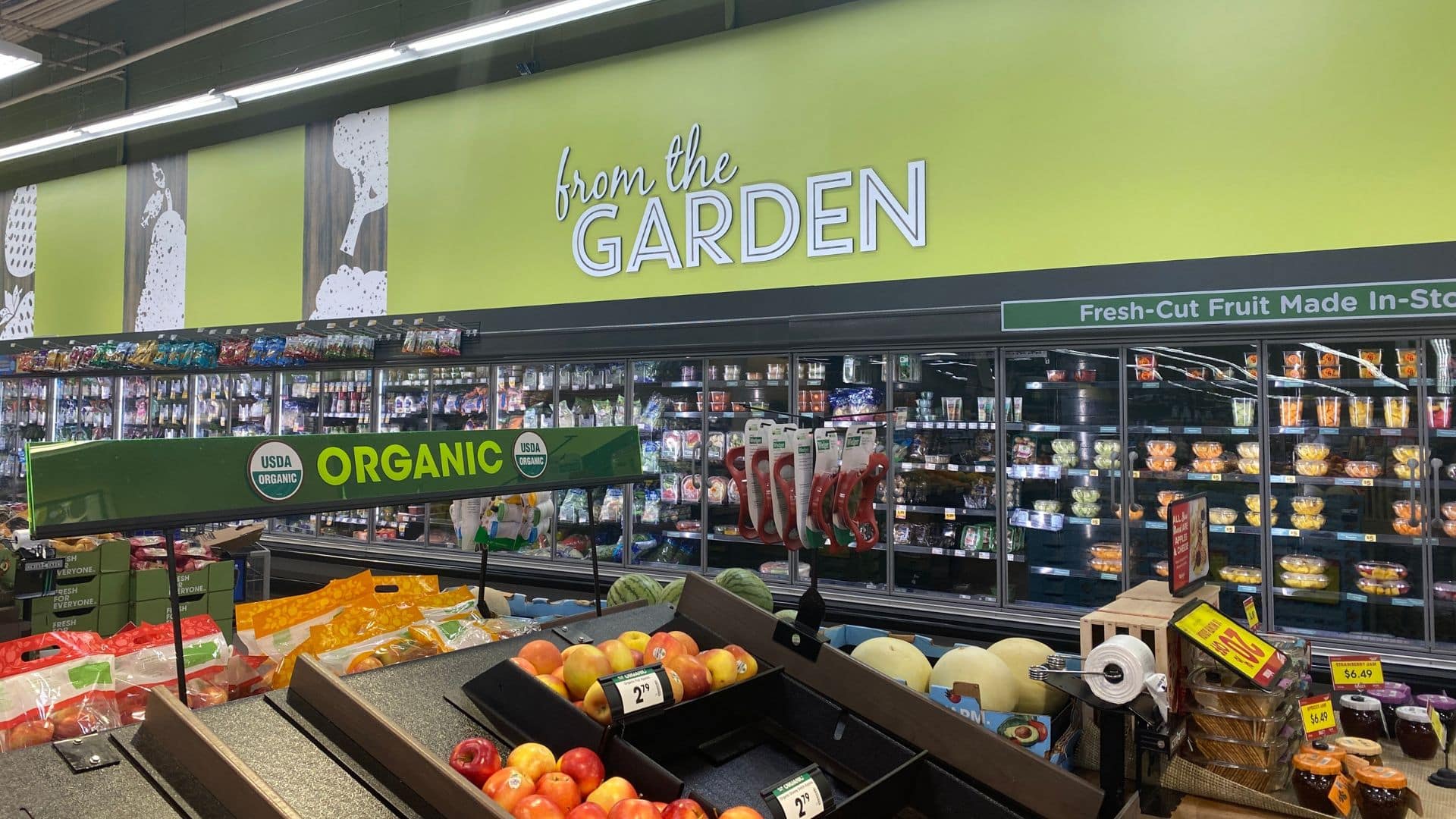 Kroger grocery store produce section with fresh apples and organic signage under bright lighting.