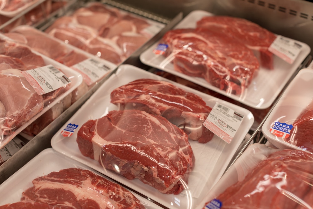 Packages of raw beef displayed in a grocery store meat section.