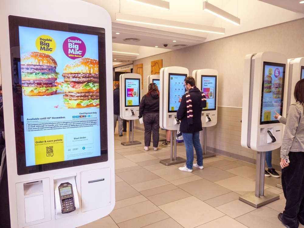 Customers use self-service ordering kiosks inside a McDonald’s restaurant.