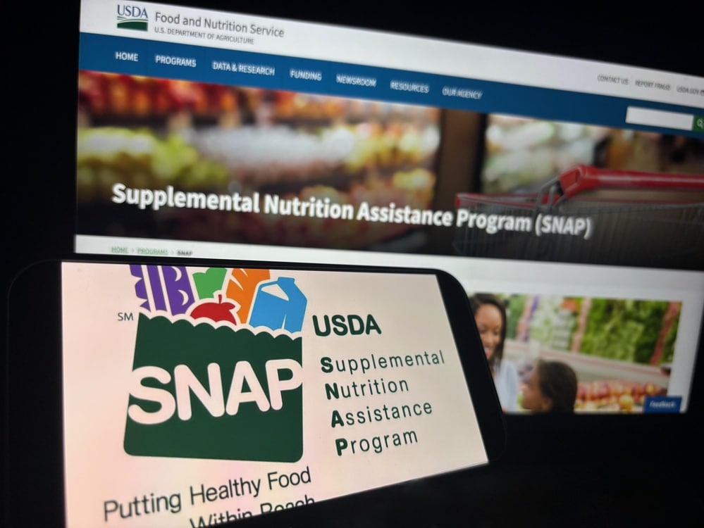 USDA Supplemental Nutrition Assistance Program webpage and SNAP logo displayed on digital screens.