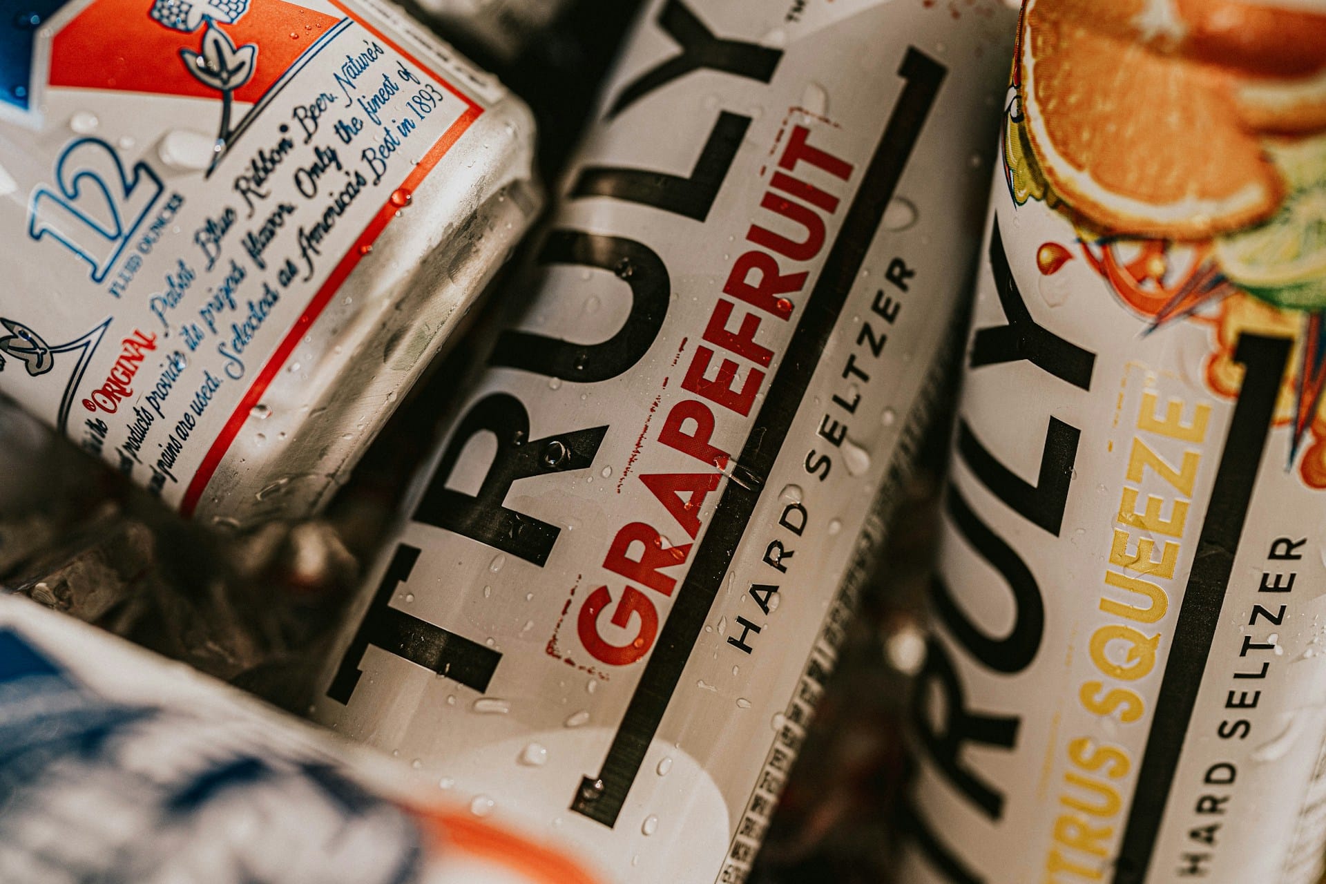 Cans of High Noon hard seltzer and Pabst Blue Ribbon beer packed in ice.