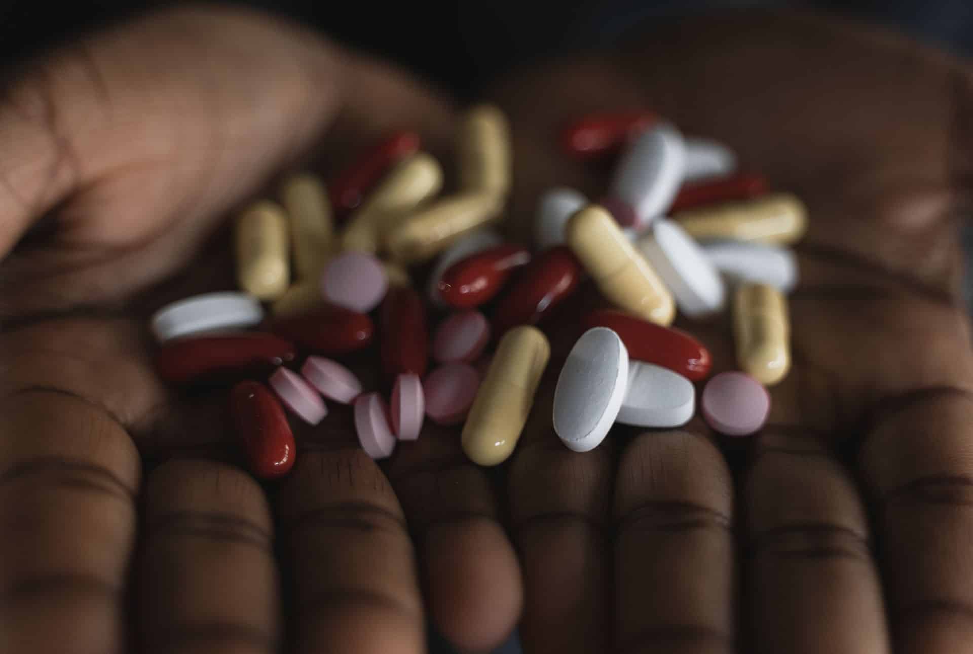 A handful of mixed prescription pills and supplements.