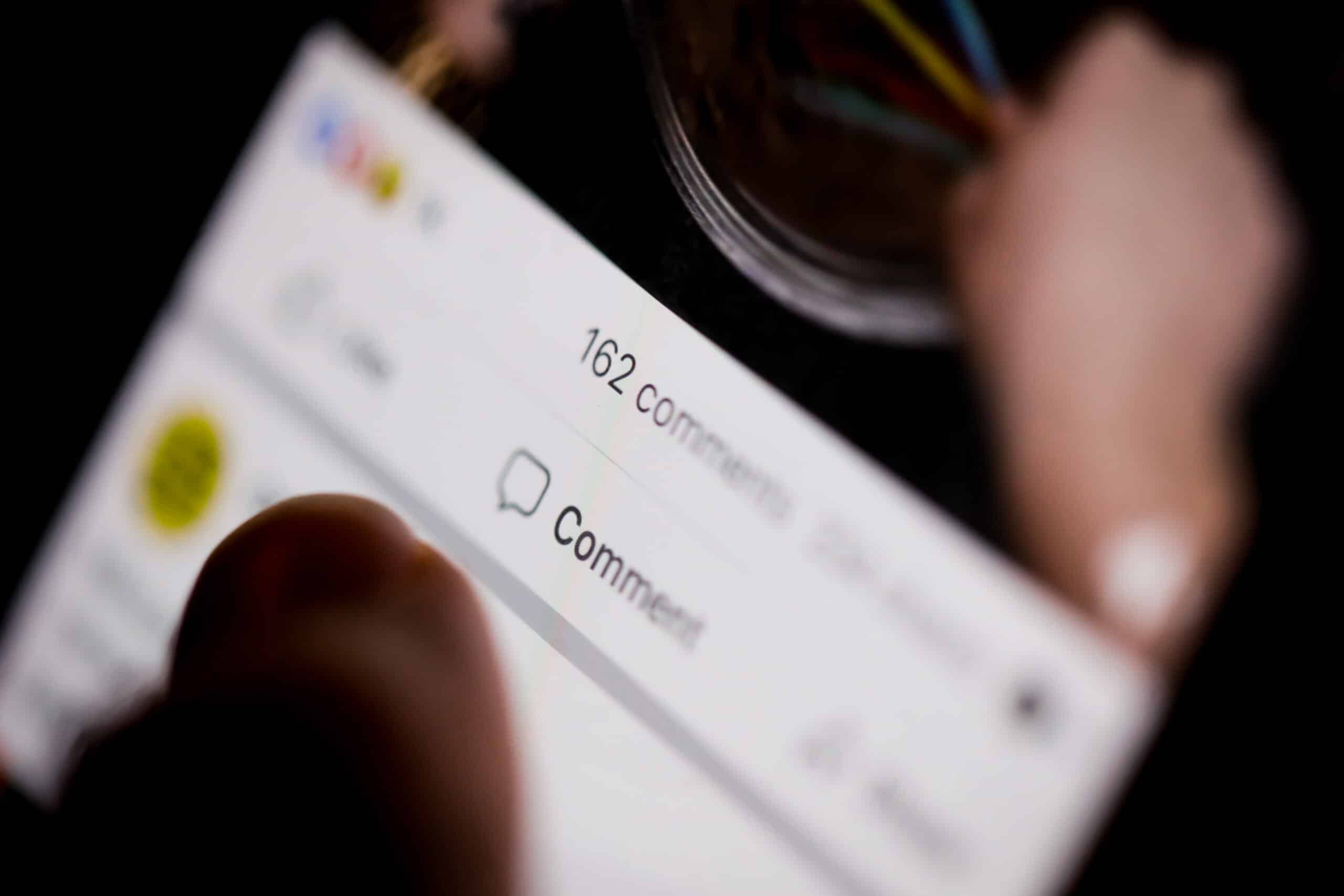 Close-up of a smartphone screen displaying a social media comment section with dozens of user responses.