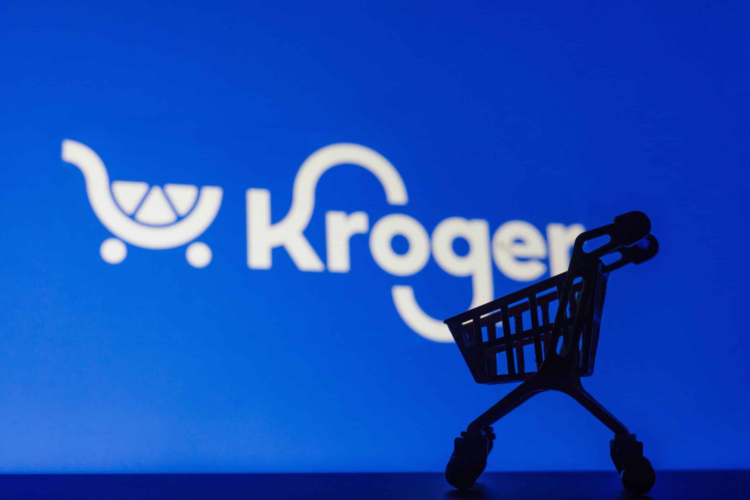 Miniature shopping cart silhouetted in front of a Kroger logo on a blue background.