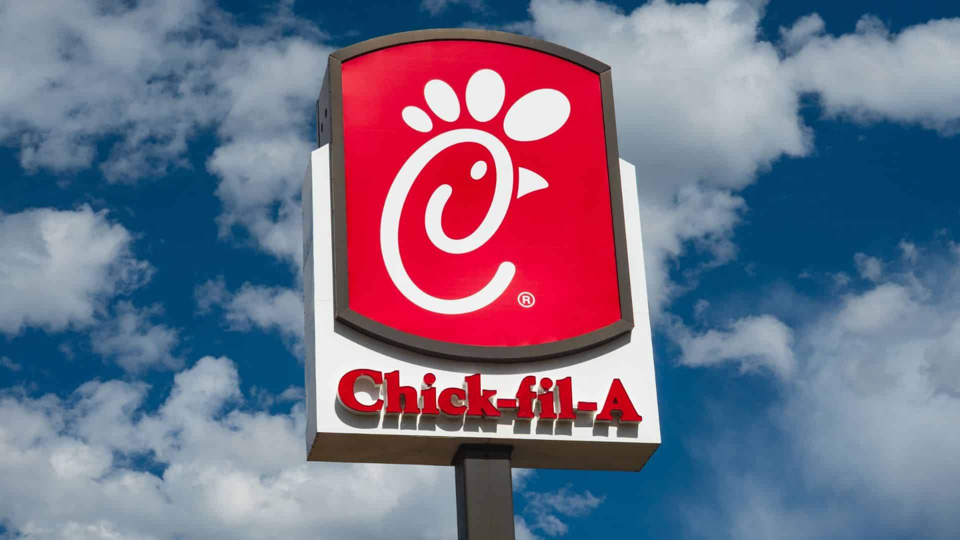 Chick-fil-A pylon sign against a partly cloudy sky.
