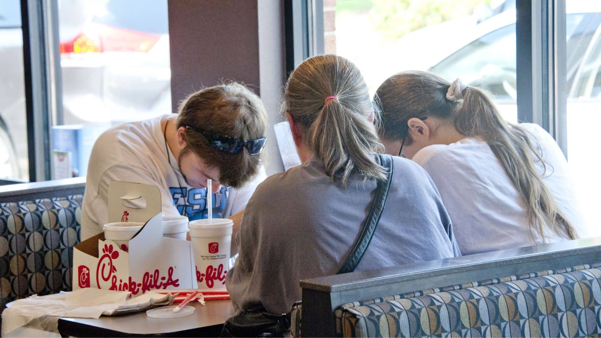 Customers seated at a Chick-fil-A dining table.