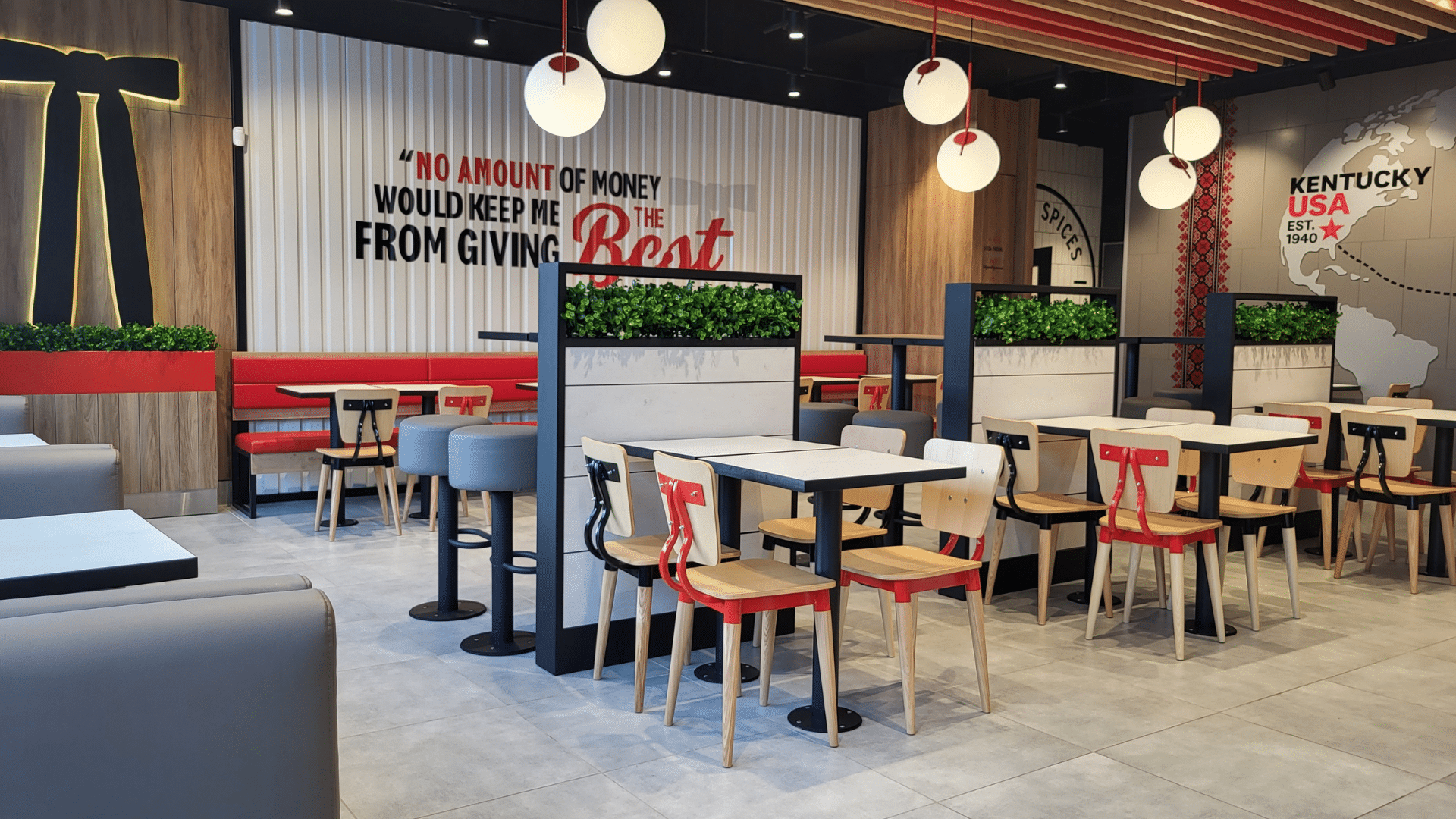 Modern dining area inside a KFC restaurant with a wall graphic quoting Colonel Sanders.