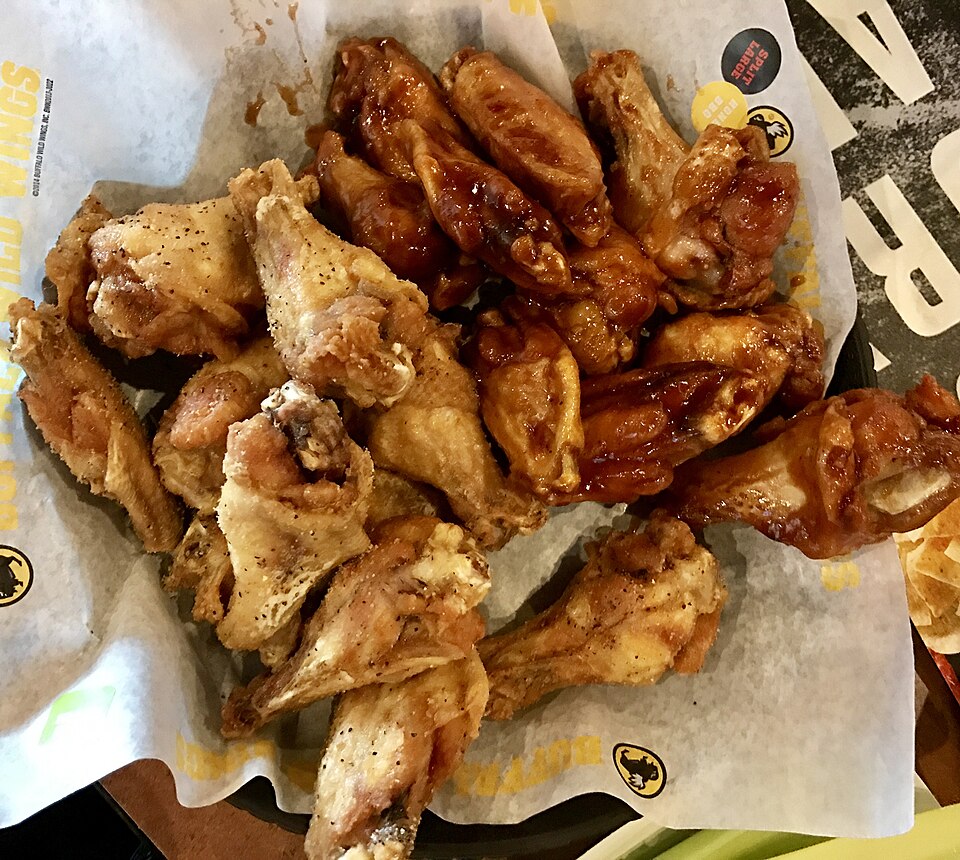 A basket of Buffalo Wild Wings chicken wings served in a mix of hot and dry rub flavors.