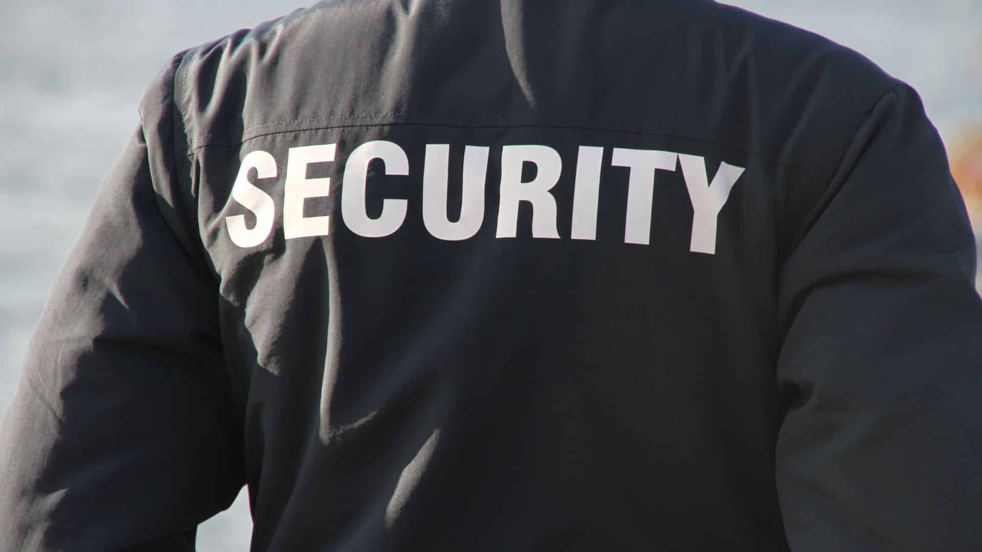 Back of a security guard's jacket with "SECURITY" printed in large white letters.