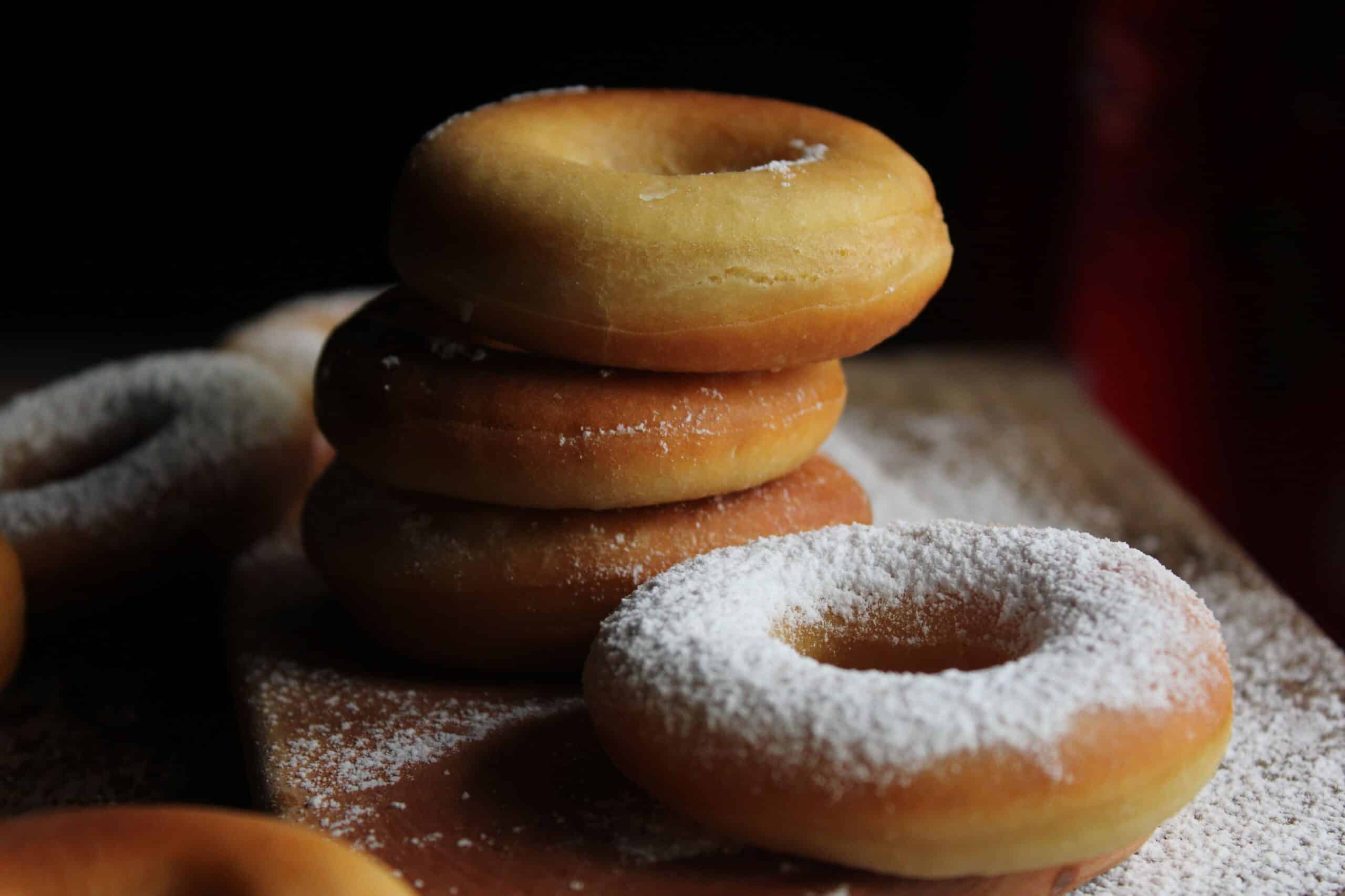 Plain and powdered donuts arranged together, illustrating the type of baked snack involved in the Donutful allergy recall.