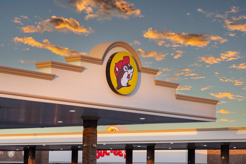 Buc-ee’s storefront sign beneath clouds lit by the setting sun.