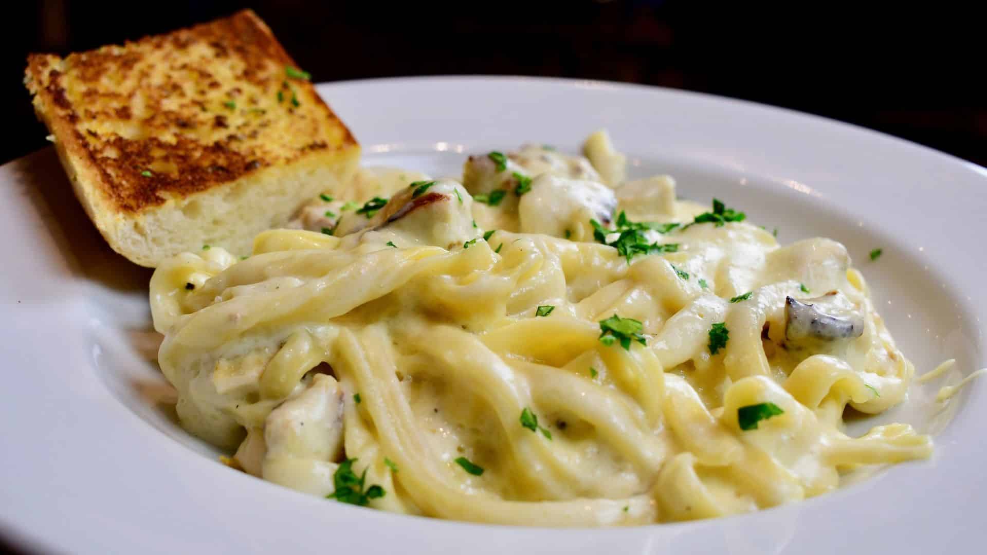 Creamy chicken fettuccine Alfredo served with garlic bread.