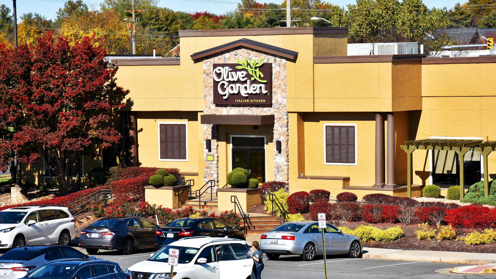 Olive Garden restaurant exterior with cars parked in front.
